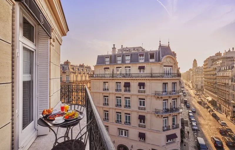 Vue imprenable sur la Seine depuis un balcon d’un hotel de Notre Dame Paris, avec les toits de Paris et le Quartier Latin en arrière-plan